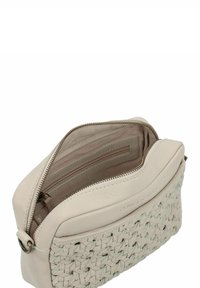 Bolso de piel crema, con textura trenzada en la parte inferior, cierre de cremallera y un interior forrado con múltiples bolsillos.