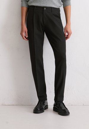 Zwarte, op maat gemaakte broeken van lichtgewicht stof met een gladde textuur, voorzien van een knoopsluiting en een slim fit. Draag ze met zwarte schoenen.
