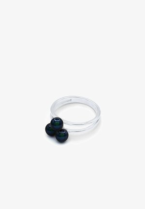 Bague ouverte en argent avec trois perles sombres irisées regroupées sur un fond blanc.