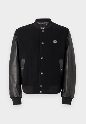 Black varsity jacket with wool body and leather sleeves. Features snap buttons, two side pockets, and a logo patch on the chest.