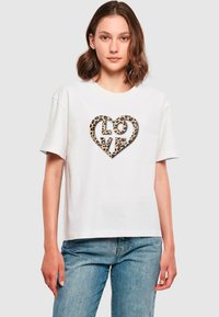 Hvid bomulds-T-shirt med et leopardprint hjerte designet og ordet "KÆRLIGHED" i centrum. Korte ærmer og afslappet pasform.