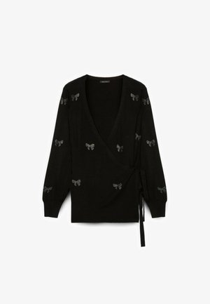 Maglione avvolgente nero con maniche lunghe, caratterizzato da dettagli in pizzo argentato. Il tessuto morbido e la chiusura con fiocco in vita aggiungono un tocco di eleganza.