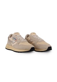 Sneakers beige con una combinazione di materiali in suede e mesh, suola imbottita, lacci piatti e etichetta con logo sulla linguetta.