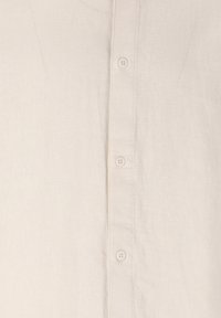 Lys beige linned skjorte med knaplukning fortil, fem knapper og et struktureret stof med et diskret afslappet udseende.