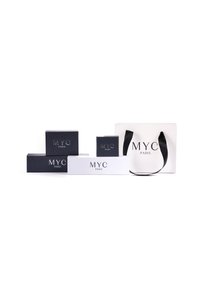 Imballaggio in bianco e nero con marchio "MYC PARIS". Include diverse dimensioni di scatole e una borsa con una tracolla nera, tutte con un design elegante.