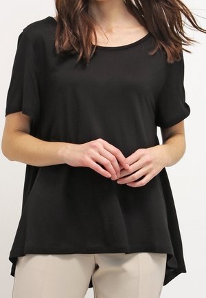 Top nero a maniche corte con scollo rotondo, vestibilità ampia e orlo posteriore leggermente più lungo. Tessuto liscio, realizzato in materiale leggero.