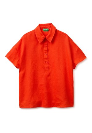 Jasno pomarańczowa lniana koszula z krótkim rękawem, z ostrym kołnierzem i listwą na trzy guziki na białym tle.