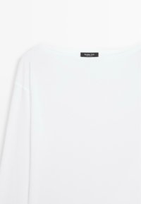 Wit shirt met lange mouwen en een ronde halslijn, met een Massimo Dutti-label aan de achterkant van de kraag.