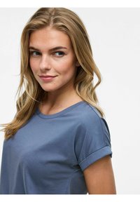 Rundhalsad, kortärmad blå bomullströja med rullade ärmslut, mjukt utseende och avslappnad passform. Har subtila skräddarsydda detaljer runt axlarna.