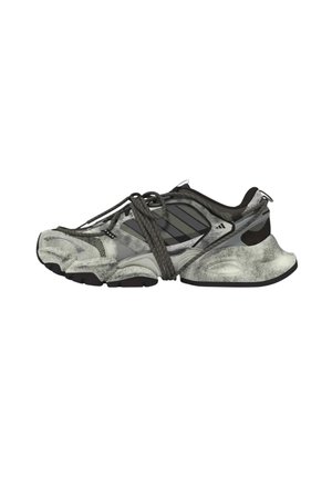 Sneaker sportiva grigia e nera con suola spessa e lacci scuri incrociati legati sopra su sfondo bianco.