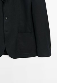 Dunkelblazer aus glattem Material, einreihiges Design und drei Knöpfe. Mit aufgesetzter Tasche und taillierter Passform.
