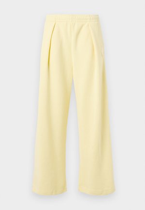 Pantalones amarillos de pierna ancha con textura acanalada y cinturilla elástica. Presentan pliegues delanteros y un pequeño diseño bordado en el lateral.