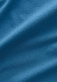 Tissu bleu avec une texture lisse, présentant un léger éclat. Le matériau a un tissage homogène sans motifs ni accessoires visibles.