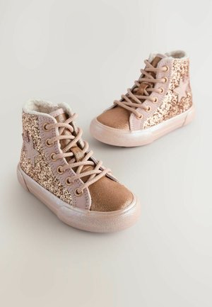 Sneakers înalte glossy de culoare roz aurie, cu accente de sclipici, detalii sub formă de stea, căptușeală din blană sintetică și talpă din cauciuc. Sforile și gulerul căptușit sunt vizibile.