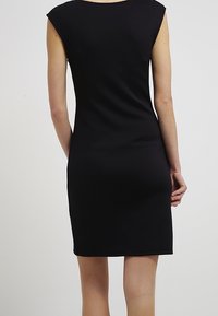 Black fitted dress with cap sleeves, made of smooth fabric. Features a simple, straight design and above-knee length. No patterns or accents.