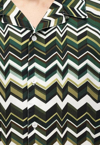 Πουκάμισο με κοντό μανίκι και κουμπιά, με σχέδιο ζιγκ-ζαγκ σε πράσινο, μαύρο και άσπρο, γιακά τύπου  καμπ και πέντε λευκά πλαστικά κουμπιά.