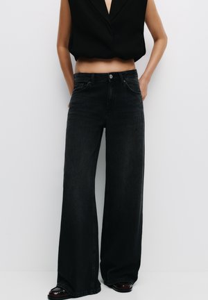 Zwarte denim skinny jeans met een hoge taille, klassiek vijf-pocket ontwerp en subtiele vervaging. De stof heeft een gladde textuur.