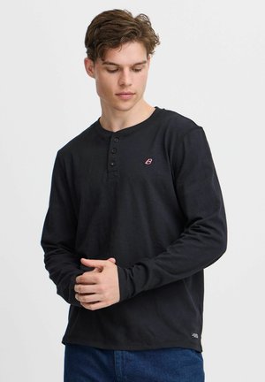 Black long-sleeve henley shirt made of textured fabric, featuring three buttons at the neckline and a small logo on the left chest.