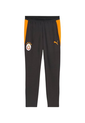 Czarne spodnie sportowe z pomarańczowymi panelami bocznymi, z logo Puma na prawej nodze i emblematem klubu piłkarskiego Galatasaray na lewej.