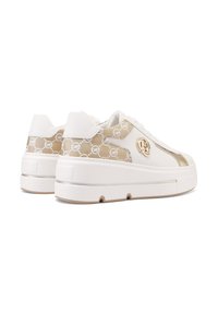 Sneaker platform bianche con accenti dorati, dotate di un pannello laterale beige con motivo, lacci frontali e dettaglio del logo sul lato esterno.
