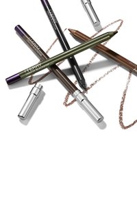Cinque matite cosmetiche di vari colori: verde oliva, marrone scuro, nero, e una custodia argentata, disposte con segni marroni simili a gessetto sotto.