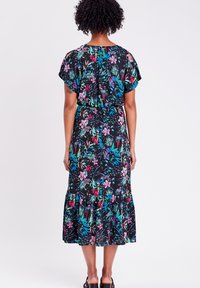 Blumenkleid mit schwarzem Hintergrund und bunten Mustern von Blumen und Blättern, mit kräuseltem Saum und kurzen Ärmeln.