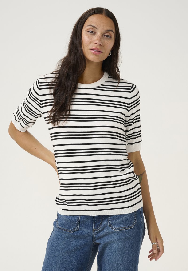 Pull en maille rayé blanc et noir avec un col rond et des manches courtes. Texture douce, coupe décontractée et construction solide.