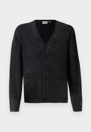 Cardigan de punto negro con escote en V, cierre de botones, dos bolsillos frontales, textura acanalada y etiqueta de marca sutil en la manga.