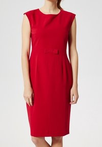 Rotes knielanges Kleid mit einer taillierten Silhouette. Hat angeschnittene Ärmel und eine Schleifenakzent an der Taille. Glatte Stofftextur.