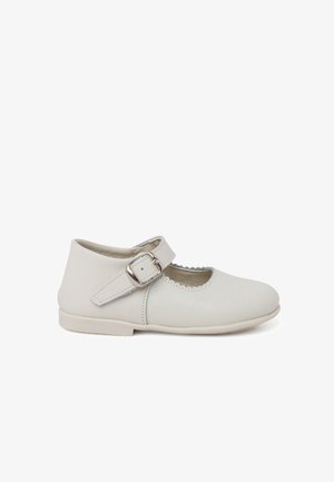 Witte leren Mary Jane-schoen met een ronde punt, verstelbare band met zilveren gesp en geschulpte randen. Platte zool.