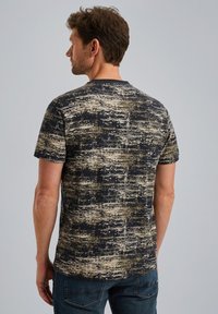 T-shirt à manches courtes avec un motif texturé en bleu foncé et beige, doté d'un col rond. Fabriqué en coton doux.