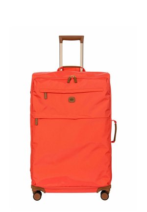 Valise souple orange vif avec poignée rétractable, poche avant zippée, poignée latérale et quatre roues pivotantes.