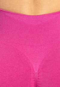 Roze rekbare legging met een geribde tailleband, featuring een gladde textuur en een subtiel V-vormig ontwerp aan de achterkant.