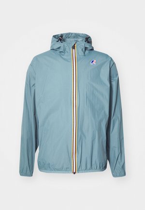 Hellblaue, leichte Jacke mit Kapuze, vollem Reißverschluss und mehrfarbigen Streifen an der Vorderseite. Hat ein Logo oben links.