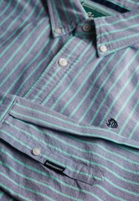 Gestreepte shirt in blauw en groen, met knopen, een kraag en een klein geborduurd logo. Inclusief een merklabel aan de zoom.