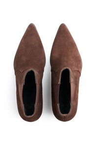 Brązowe zamszowe buty z ostrym noskiem, elastycznymi panelami po bokach i gładkim skórzanym wnętrzem. Charakteryzują się teksturowaną powierzchnią i smukłym designem.