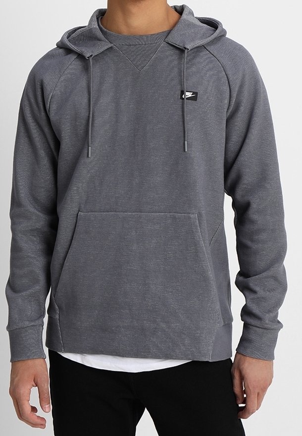 Grå huvtröja med ficka fram, justerbar dragsko i huven och en liten logo på bröstet. Tyget har en strukturerad yta.