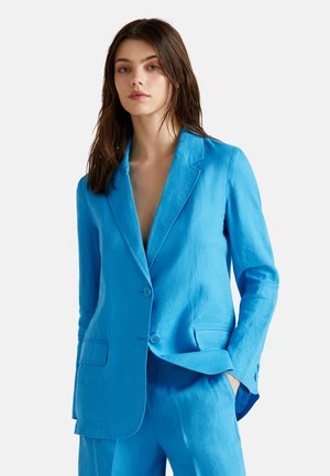 Blazer de lino azul brillante con solapas notch, cierre de dos botones y bolsillos laterales. La tela tiene un acabado ligero y texturizado.