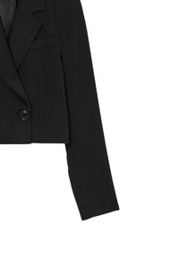Blazer nero cropped con finitura satinata, caratterizzato da un design doppiopetto, chiusura con un bottone e rever a punta. Maniche lunghe.