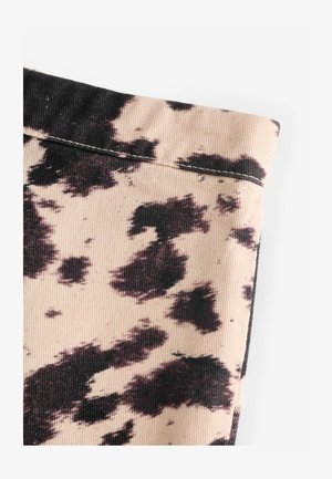 Beige Stoff mit schwarzem Kuhfleckenmuster, ausgestattet mit geriffelter Textur und schlichten Nahtdetails. Keine sichtbaren Beschläge oder Akzente.