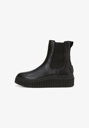 Zwarte leren enkelboot met elastische zijpanelen, ronde neus en een dikke, geribbelde rubberen zool voor grip. Minimalistisch design en matte afwerking.