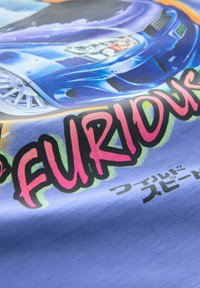 T-shirt med grafik med et blåt sportsvogn-design på et lyseblåt stof. Texten står med fed pink og læser "FURIOUS" med sorte accenter og japanske tegn.