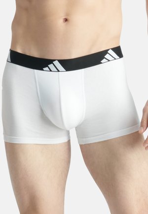 Weiße Baumwollboxershorts mit einem schwarzen elastischen Bund, der mit weißen Adidas-Logo-Streifen verziert ist. Mittellange Oberschenkel-Länge mit flachen Nähten.