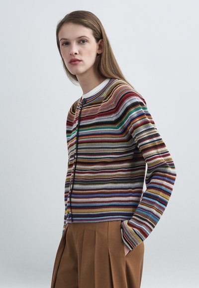 Cardigan rayé multicolore avec texture côtelée, présentant un col rond, une fermeture à boutons et des manches longues. Assorti à un pantalon plissé marron.