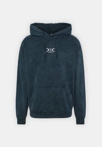 Mörkblå hoodie gjord av mjuk tyg, med en känguruficka, ribbade ärmslutar och nederkant, samt en vit logotyp tryckt på bröstet.