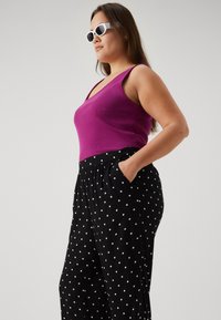 Vero Moda Curve VMCBUMPY WIDE - Trousers - black/white