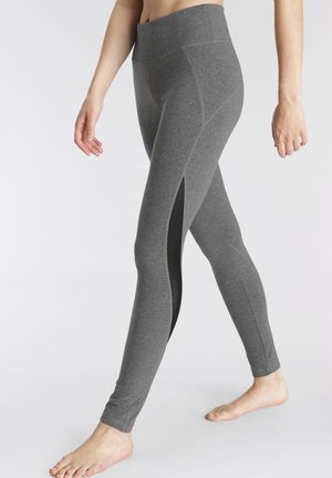 Graue Leggings aus weichem Stoff mit seitlichen Netzcutouts, hoch geschnittenem Taillenbund und figurbetontem Design, das eine glatte Textur zur Schau stellt.