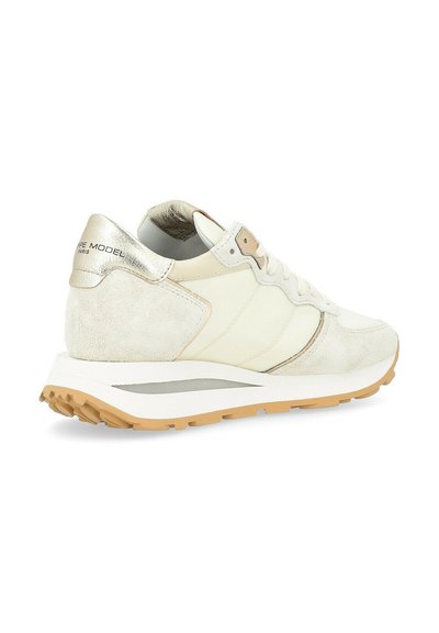 Sneaker with a white and metallic gold design, featuring a suede texture, rounded shape, padded collar, and a light rubber sole.