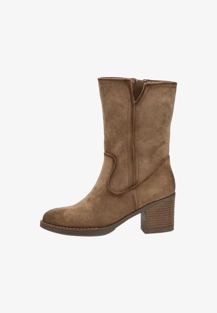 Bota de tobillo de ante marrón con punta redonda, presenta un diseño de costura sutil y un tacón apilado. Textura suave con una silueta clásica.