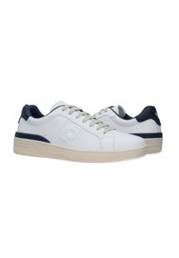 Sneaker bianche in pelle liscia con suola in gomma, caratterizzate da un accento blu navy sulla parte posteriore e un design del logo sul lato.